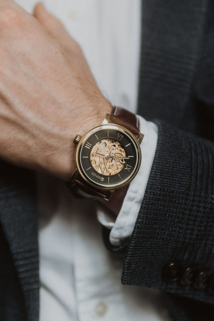 A closeup of a yellow gold and leather luxury watch.
