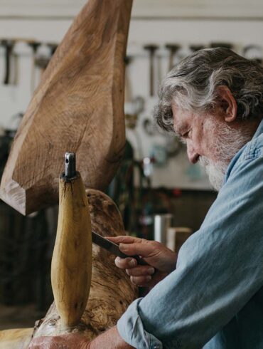 a person (James Surls) carving a piece of wood