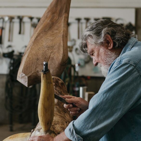 a person (James Surls) carving a piece of wood