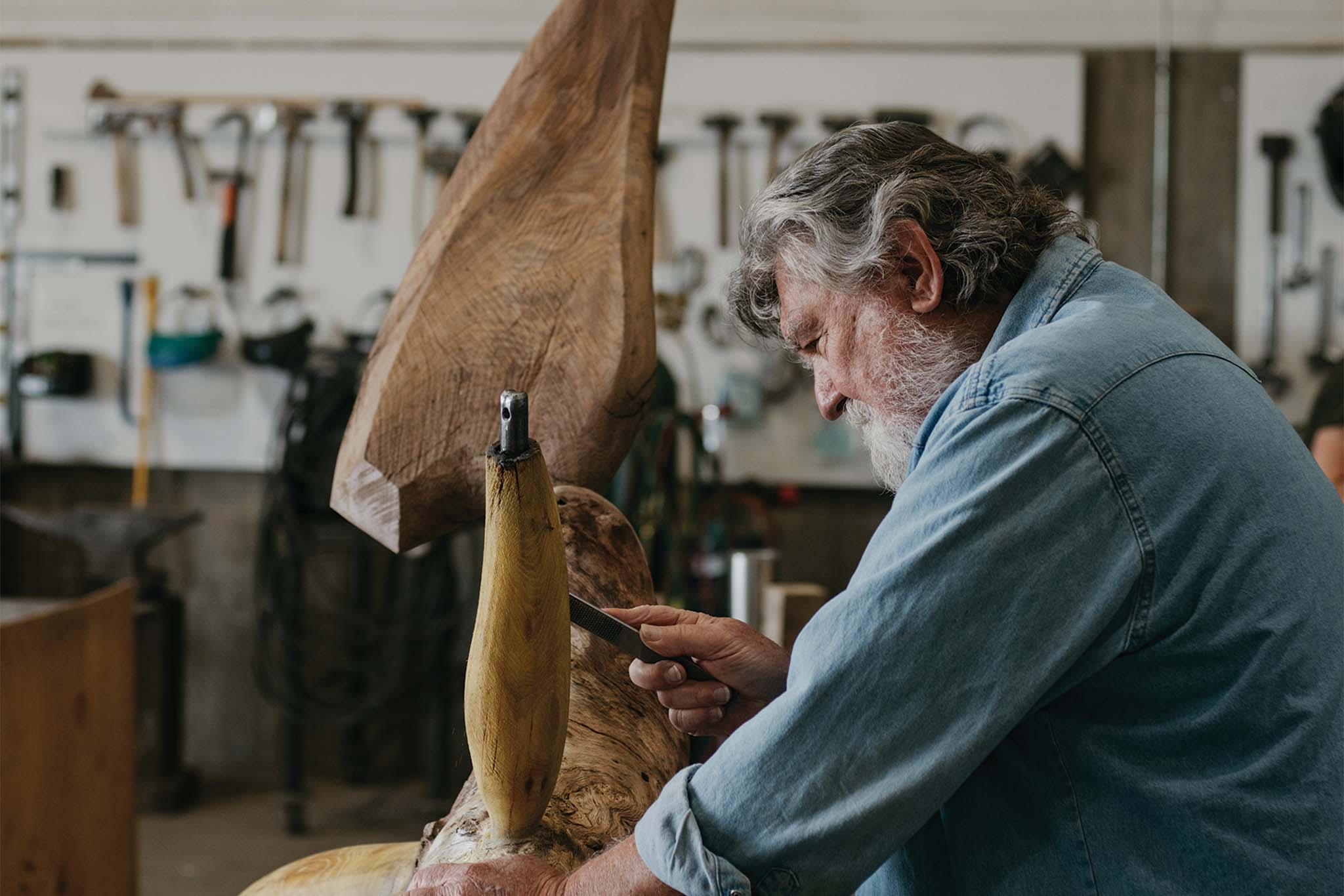 a person (James Surls) carving a piece of wood