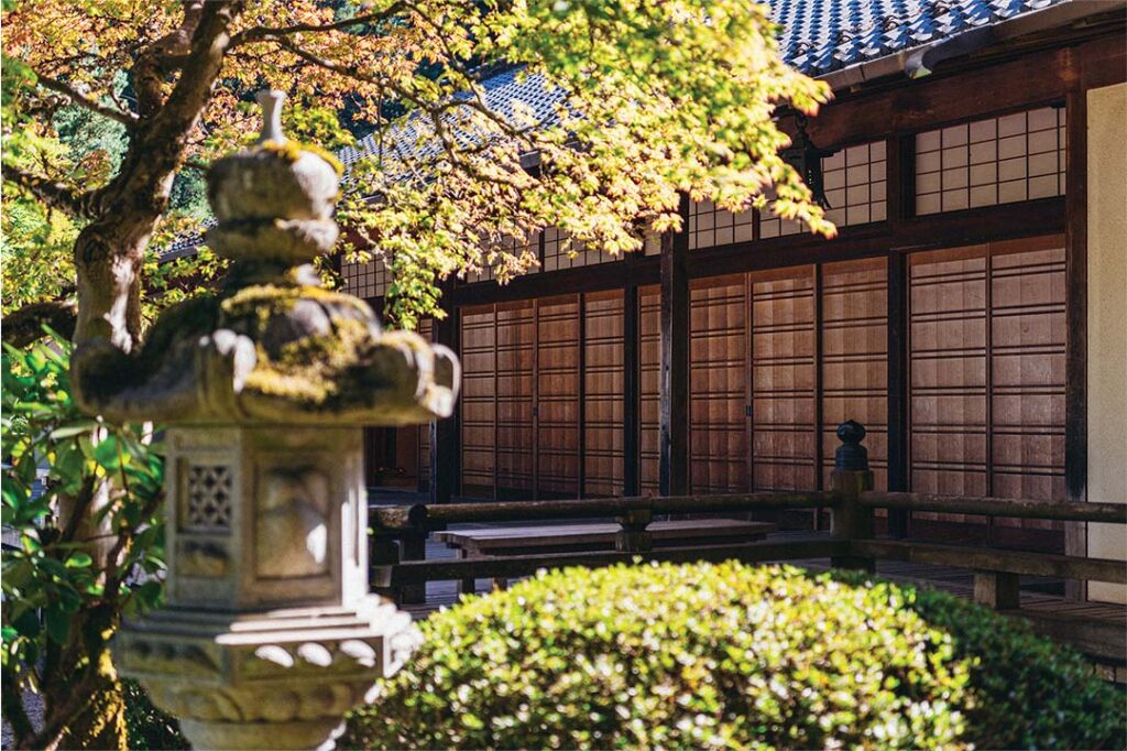 a stone statue in front of a building in a Japanese Garden