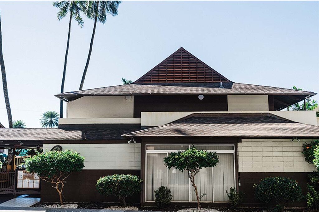 a house with trees and a window with the distinct hawaiian-style architecture
