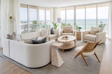 a living room with a large glass wall and a couch and a table