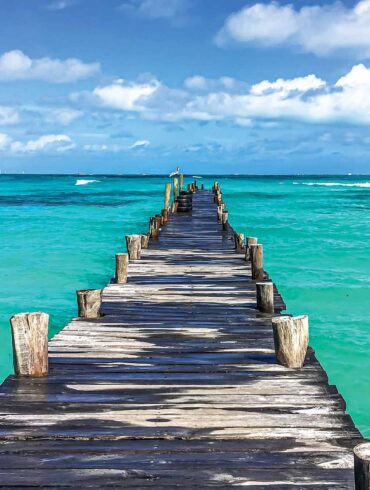 a wooden dock leading into the ocean