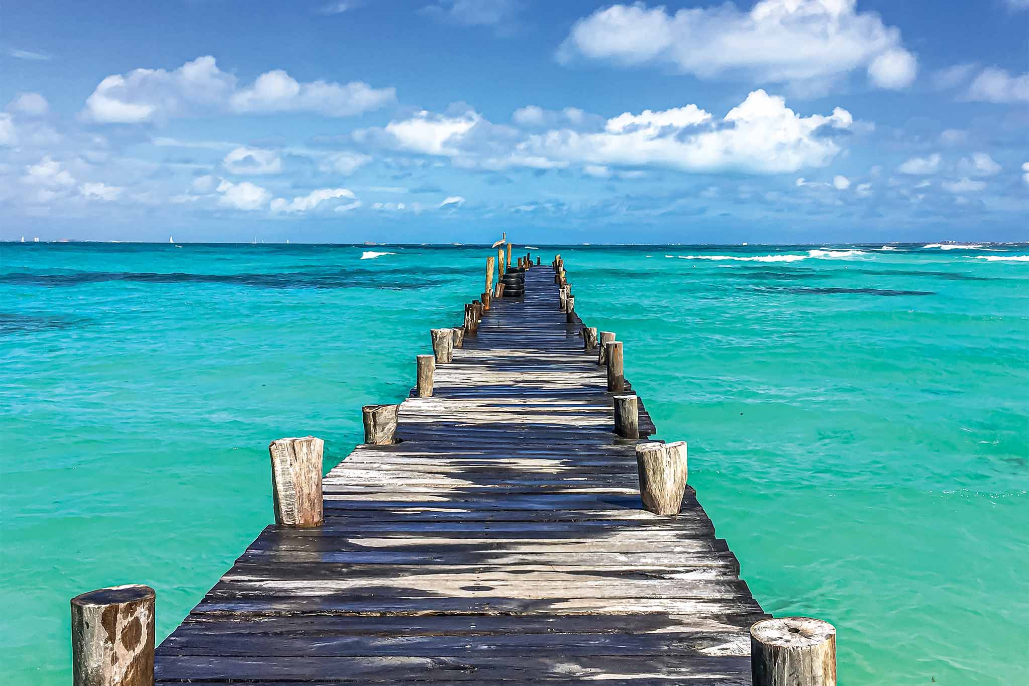 a wooden dock leading into the ocean