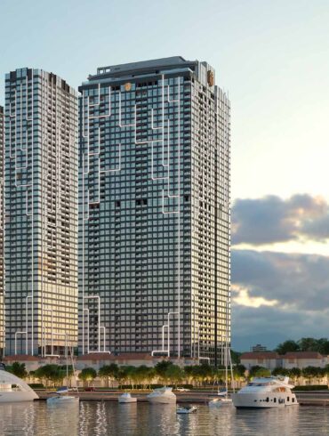 a group of tall buildings next to a body of water