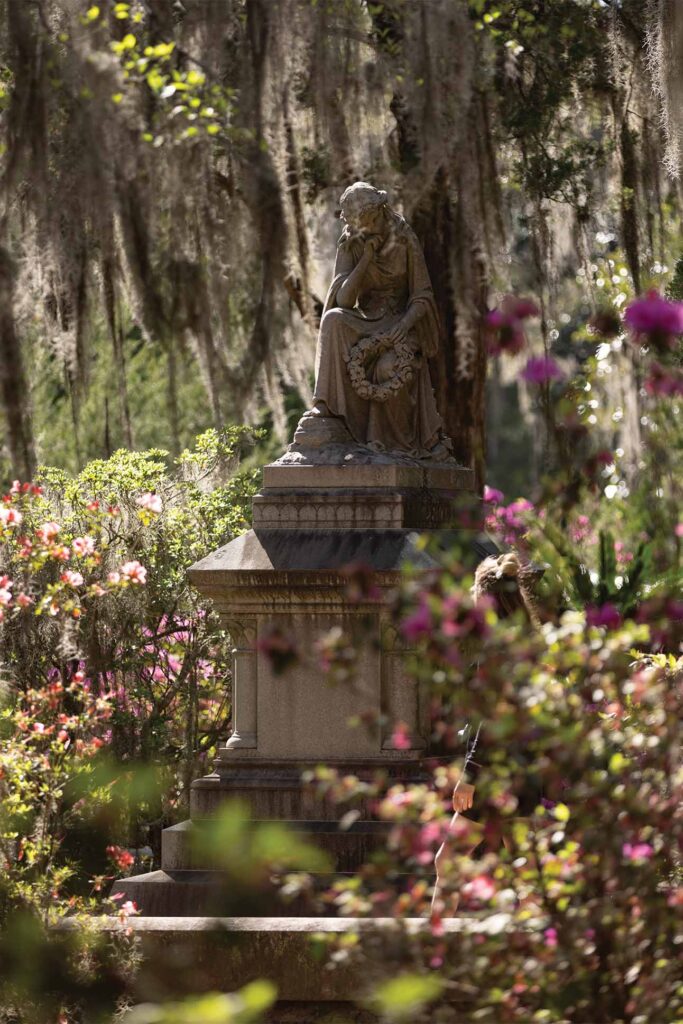 a statue in savannah goergia covered in lush greenery